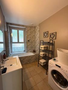 y baño con bañera y lavadora. en Le carré Gambetta, en Carcassonne