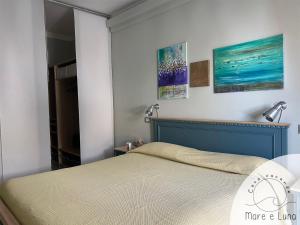 ein Schlafzimmer mit einem Bett und zwei Gemälden an der Wand in der Unterkunft Casa vacanze - Mare e Luna in Montesilvano