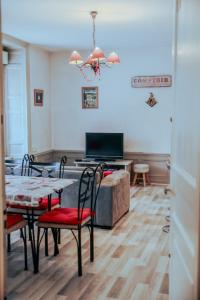 Le Cosy في جوراردُميه: غرفة معيشة بها طاولة وكراسي