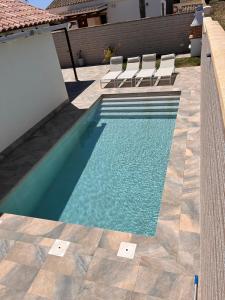 Una piscina con sillas al lado de una casa. en CASA Marimonte, en Conil de la Frontera