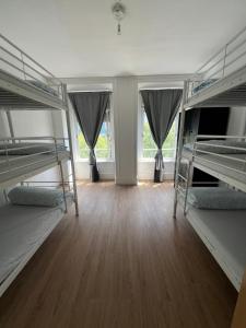 a room with three bunk beds and a wooden floor at Bagetti hostel only for girls in Lisbon
