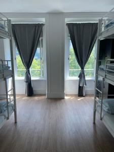 a room with two bunk beds and two windows at Bagetti hostel only for girls in Lisbon