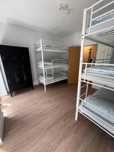 a room with two bunk beds and a wooden floor at Bagetti hostel only for girls in Lisbon