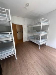 two bunk beds in a room with a wooden floor at Bagetti hostel only for girls in Lisbon