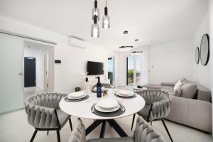 a white living room with a table and chairs at Prestige Apartment Primošten in Primošten +42 photos