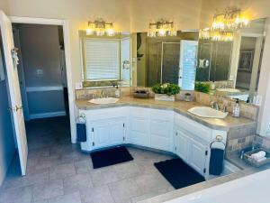 a bathroom with two sinks and two mirrors at Pinkie's Suite -Hot Tub-BBQ-views in Ahwahnee