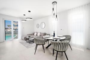 a white living room with a table and chairs at Prestige Apartment Primošten in Primošten
