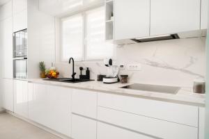 a white kitchen with white cabinets and a sink at Prestige Apartment Primošten in Primošten
