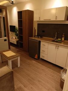a kitchen with white cabinets and a black refrigerator at Palma House in Hurghada