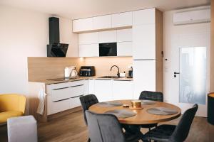 a kitchen with a table and chairs in a room at Apartmány DVĚ BOBULE 2KK in Pasohlávky