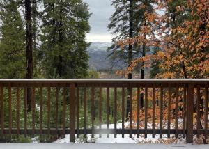 a wooden fence with a view of the mountains at Yosemite Quail - Nestled in with a View in Yosemite West