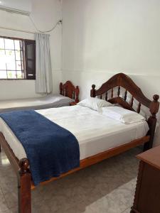 a bedroom with a bed with a blue blanket on it at Casa dos dormitorios in Bella Vista