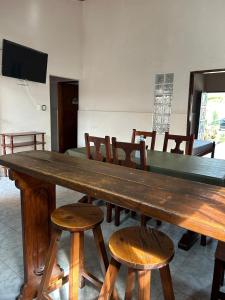a large wooden table with chairs and a television at Casa dos dormitorios in Bella Vista