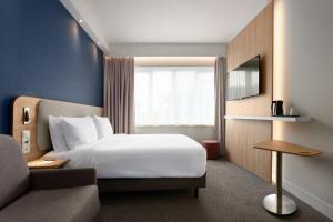 a hotel room with a bed and a couch at Holiday Inn Express Hasselt by IHG in Hasselt