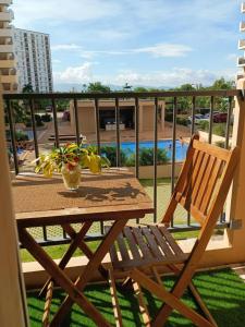 a wooden table and a chair on a balcony at Homey Apartment with Olympic-sized pools in Lapu Lapu City
