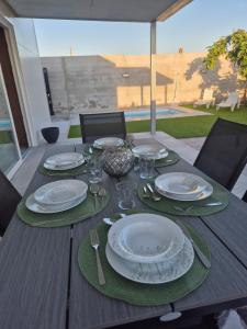 a wooden table with plates and silverware on it at Casitalola in Conil de la Frontera