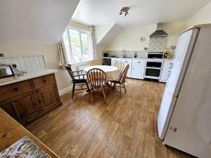 a kitchen with a table and chairs and a refrigerator at Spacious apartment in Bicknoller in Bicknoller
