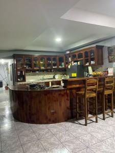 a kitchen with a wooden island in a room at Lirio green hostal in Managua
