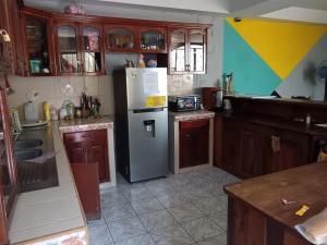 a kitchen with a refrigerator and wooden cabinets at Lirio green hostal in Managua +22 photos