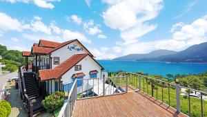 a building with a staircase next to the water at Sinbibada pension in Geoje 