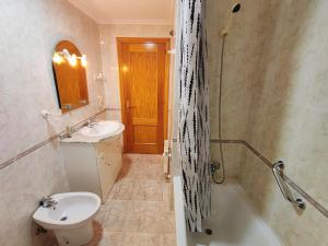 une salle de bain avec un lavabo, des toilettes et une baignoire dans l'établissement Apartamento Rosalía de Castro Ribadeo, à Ribadeo 18 autres photos