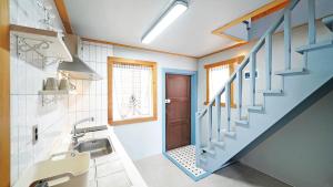 a bathroom with a sink and a blue staircase at Sinbibada pension in Geoje  +158 photos