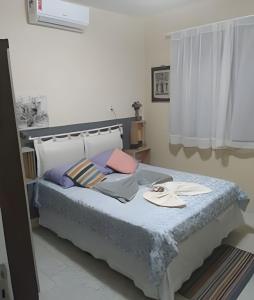 Un dormitorio con una cama con sábanas azules y una ventana. en Oceana Suites Pousada Meireles, en Fortaleza