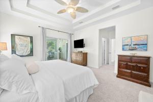 a white bedroom with a bed and a ceiling fan at Dog-Friendly 4BR Coastal Getaway Close to Beach in Saint Augustine