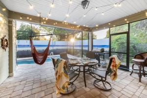 a screened in porch with a table and chairs at Dog-Friendly 4BR Coastal Getaway Close to Beach in Saint Augustine