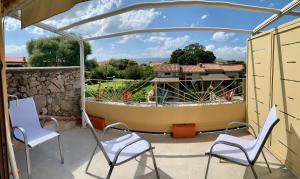 a patio with two chairs and a boat on it at Villaggio La Cinta in San Teodoro