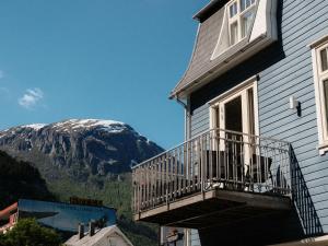 a house with a balcony with a mountain in the background at Blue House Odda in Odda