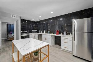 a large kitchen with a stainless steel refrigerator at Charming Getaway in Houston Heights in Houston +7 photos