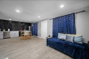 a living room with a blue couch and a kitchen at Charming Getaway in Houston Heights in Houston