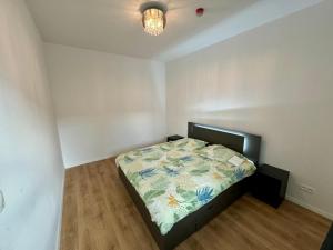 a small bedroom with a bed with a floral comforter at Lovely 2 bedroom near city centre Bratislava in Brenner