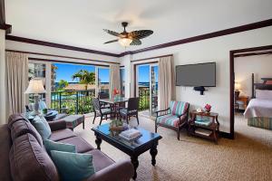 a living room with a couch and chairs and a television at Waipouli Beach Resort Exquisite Ocean View Condo With Beach Front View! AC Pool in Kapaa