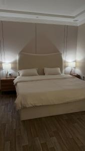 ein Schlafzimmer mit einem weißen Bett mit zwei Lampen in der Unterkunft Apartment room and hall private entrance in Al-Malqa neighborhood in Quai