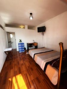 a bedroom with two beds and a television on the wall at Ugarte Street in Trujillo