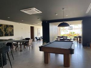 a pool table in a room with tables and chairs at Apartamento pie de playa in Mazatlán