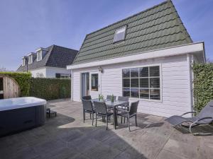 a patio with a table and chairs and a tub at t Kaatsheuveltje 1 in Sprang-Capelle