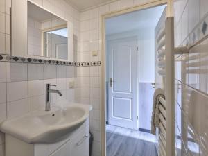 a white bathroom with a sink and a mirror at t Kaatsheuveltje 7 in Sprang-Capelle +25 photos