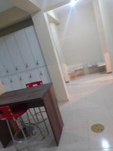 Habitación con mesa de madera y 2 sillas rojas. en Residencia, en Lima