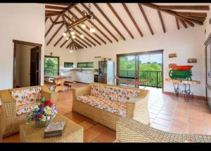 a living room with couches and a kitchen at Tu casa cafetera in Quimbaya
