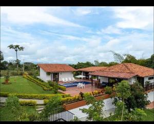 a house with a patio and a yard with a pool at Tu casa cafetera in Quimbaya