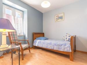 a small bedroom with a bed and a chair at Gîte Authentique au Cœur des Vignes avec Terrasse Privative et Wifi, à 25 km de Nantes - FR-1-306-813 in Le Landreau