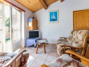 Una sala de estar con un sofá y un televisor. en Gîte au Calme avec Jardin, Proche Plages, 2 Chambres, Vélos et Randonnées à Machecoul - FR-1-306-805, en Machecoul