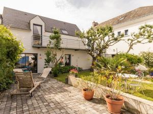 a patio with chairs and plants in front of a house at Gîte calme près de plages, au cœur de Batz-sur-Mer, terrasse sud, wifi, et équipements bébé - FR-1-306-840 in Batz-sur-Mer