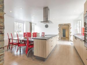 a kitchen with a dining table and red chairs at Gîte rénové près de la mer avec jardin clos, cheminée, Wifi et équipements bébé inclus. - FR-1-306-879 in Saint-Hilaire-de-Chaléons