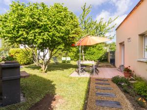 a garden with a table and an umbrella at Charmant Gîte avec Jardin Clos au Cœur du Parc de Brière, Proche La Baule et Guérande - FR-1-306-863 in La Chapelle-des-Marais
