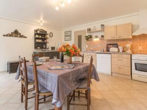 a kitchen with a table with a vase of flowers on it at Maison familiale avec piscine, grand jardin clos et équipements de loisirs - FR-1-306-898 in Bonnoeuvre