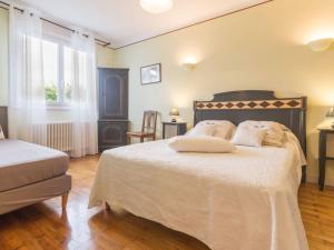 a bedroom with a large bed and a window at Maison familiale avec piscine, grand jardin clos et équipements de loisirs - FR-1-306-898 in Bonnoeuvre +11 photos